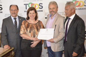 Marco Alba, ao centro e de barba, recebendo do governador Sartori o certificado de redução da mortalidade infantil