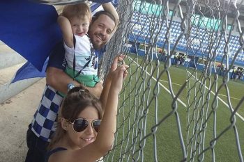 Eduardo no alambrado do estádio Passo Da Areia - a casa do Zequinha - com a filha Júlia e o filho Miguel